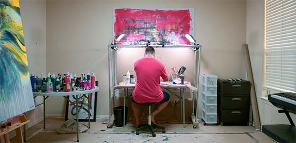 Preston Zeller in his studio, painting at his workstation